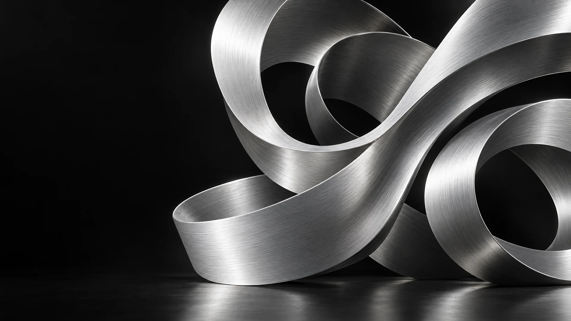 A flowing silver ribbon sculpture on black